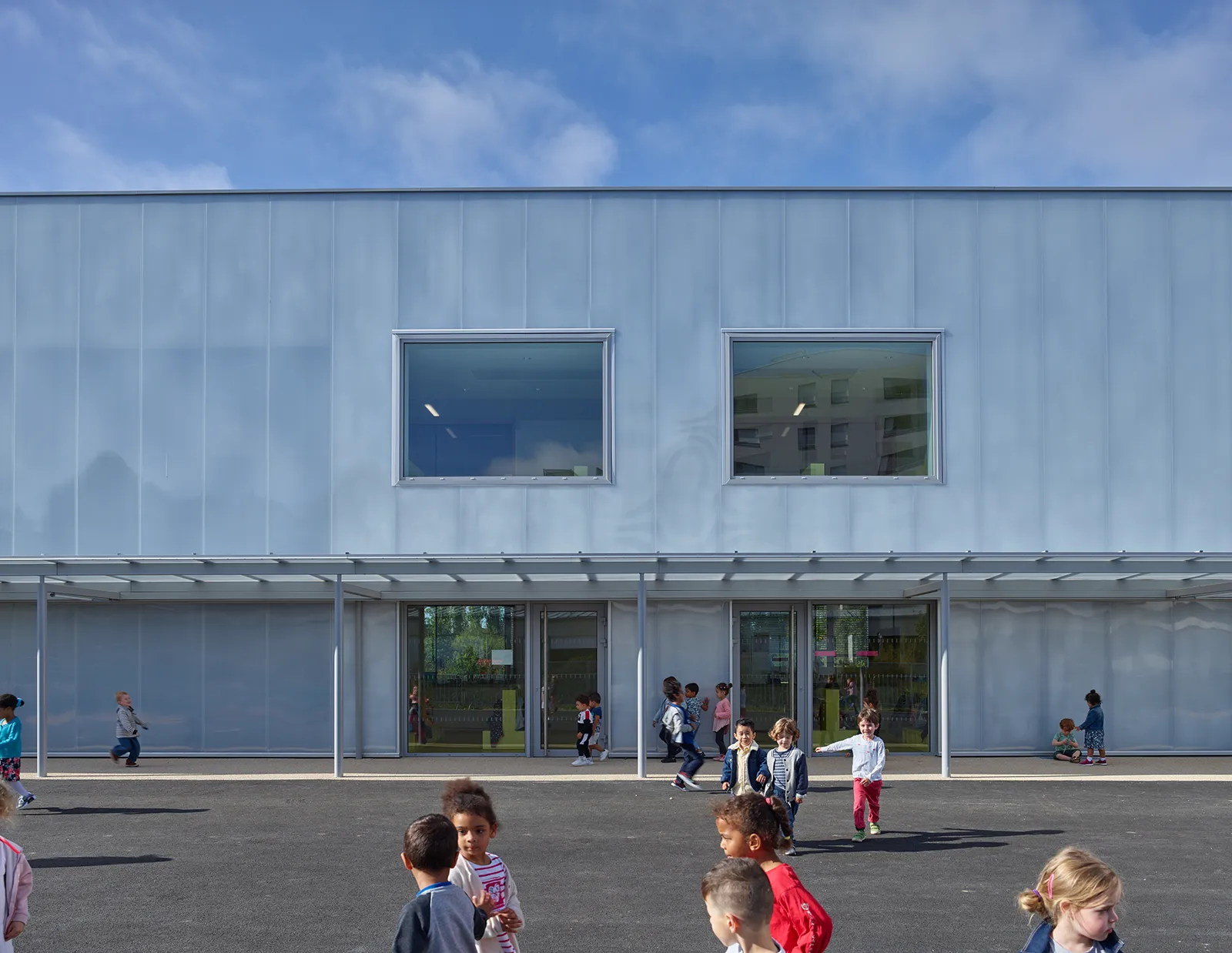 Vue de la façade en polycarbonate sur cour de l’école maternelle et accueil périscolaire à Saint-Jaques de la Lande