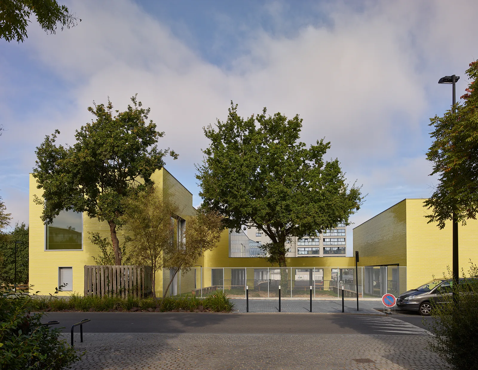 Vue en transparence depuis la rue sur la cour de l’école maternelle et accueil périscolaire à Saint-Jaques de la Lande