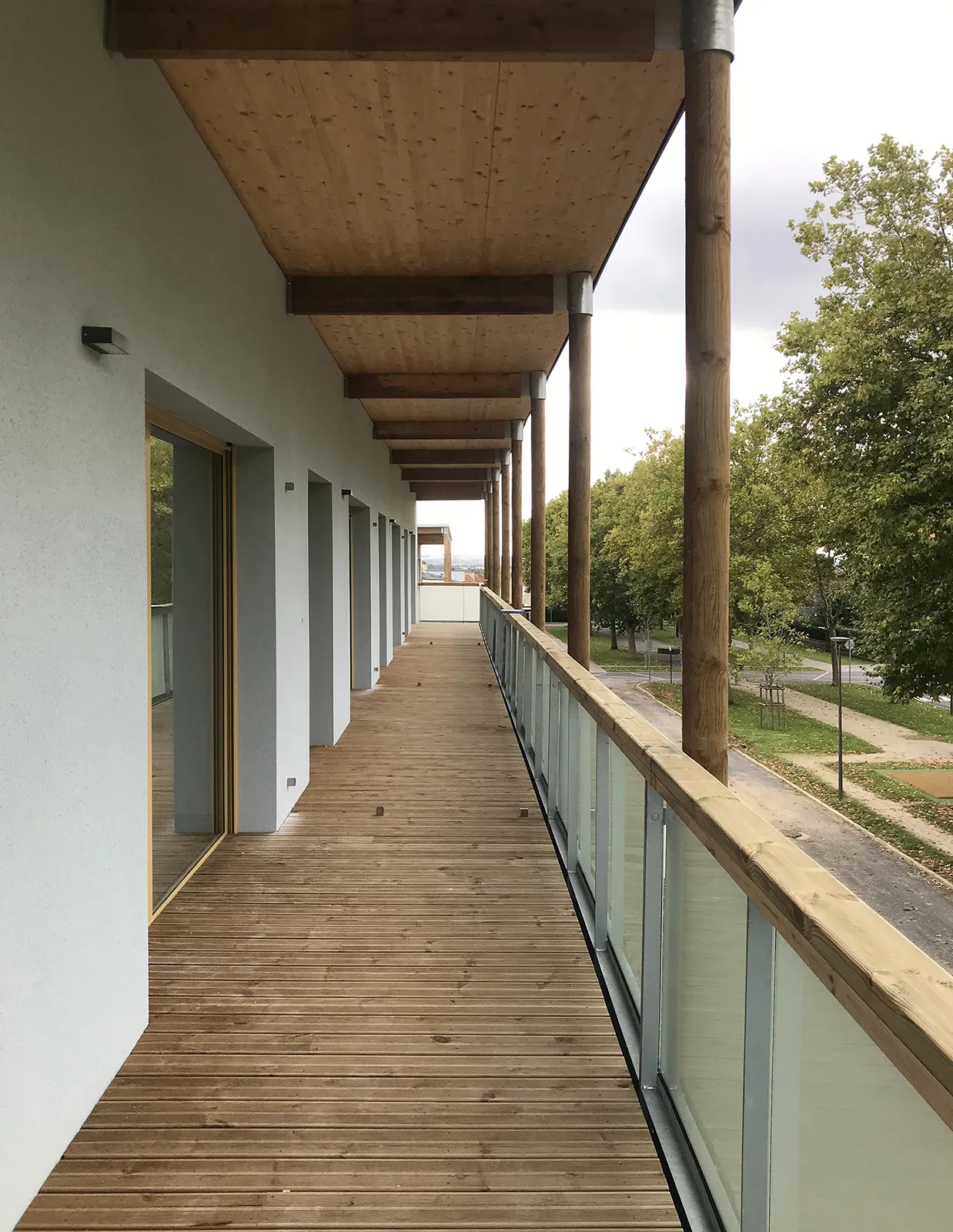 Vue du balcon filant ossature bois du dernier étage des logements à coursives à Colombelles