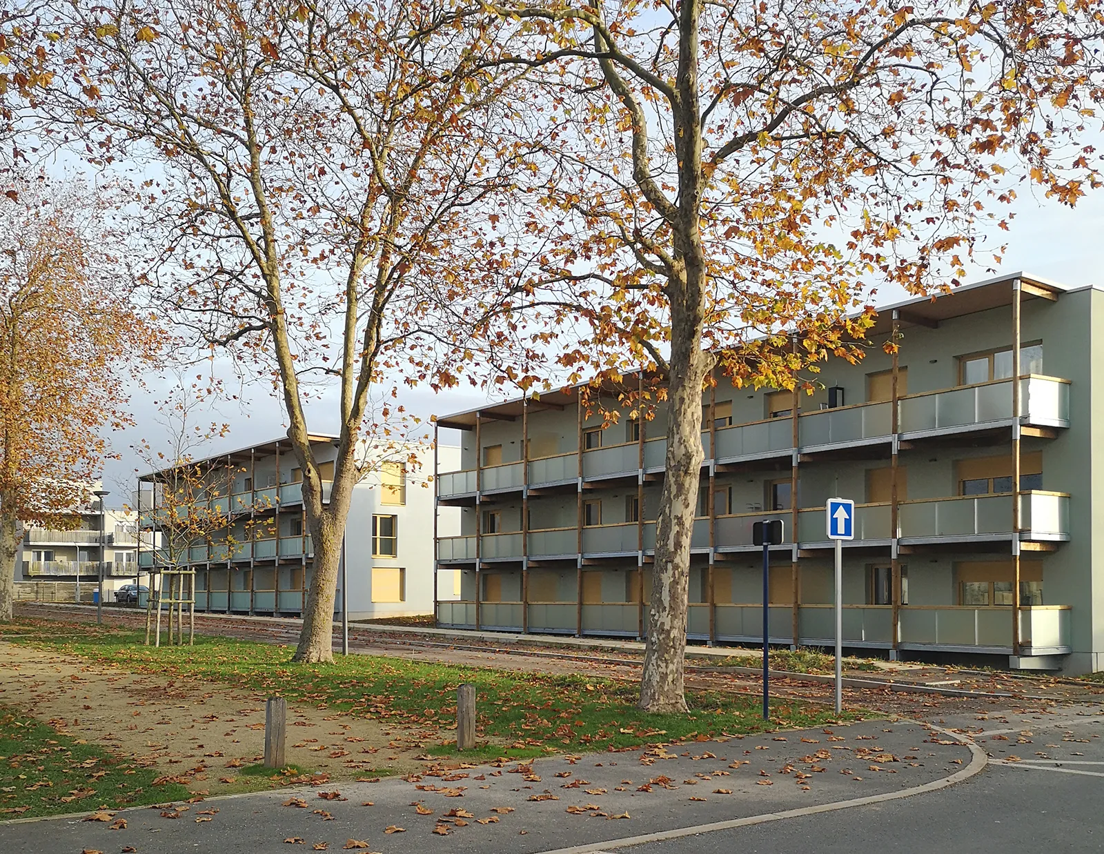 Vue des deux bâtiments de logements à coursive depuis le mail planté