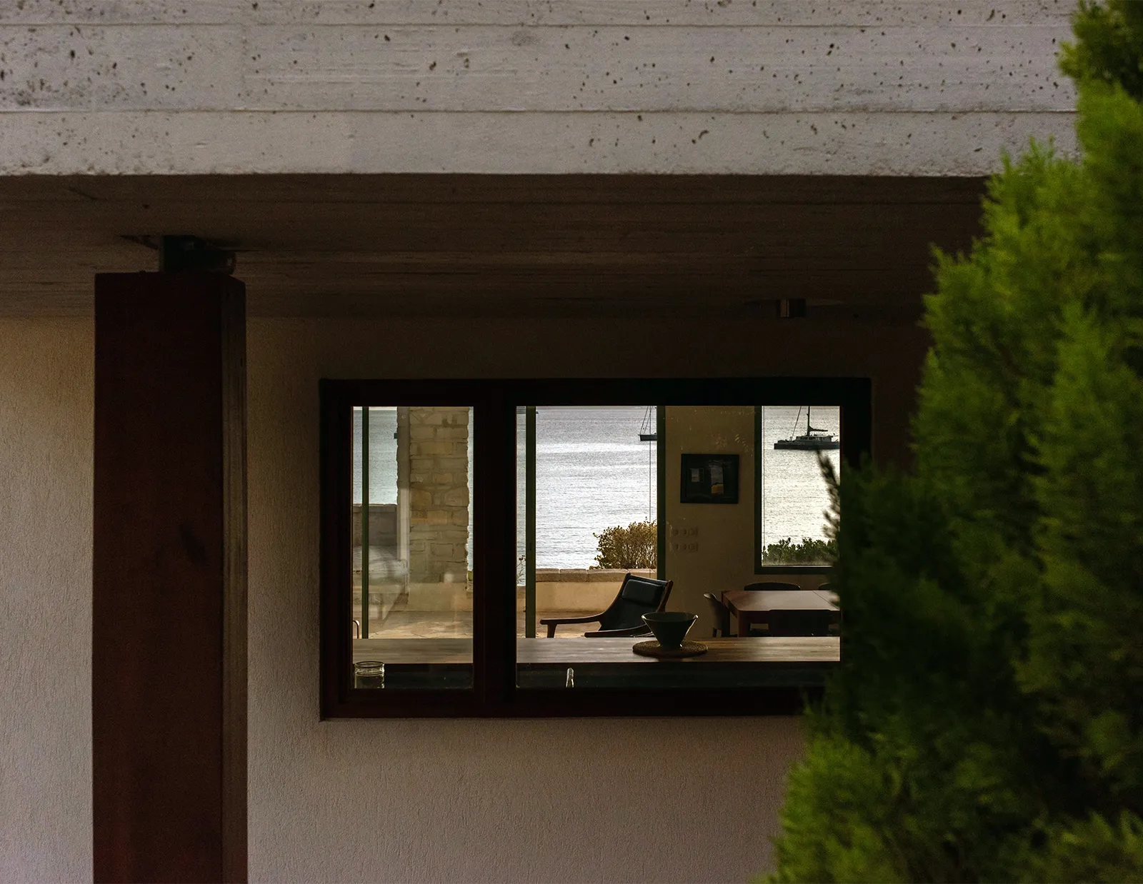 Vue en transparence sur la mer à travers la fenêtre de la cuisine depuis l’entrée de la maison à Saint-Cyr-sur-Mer